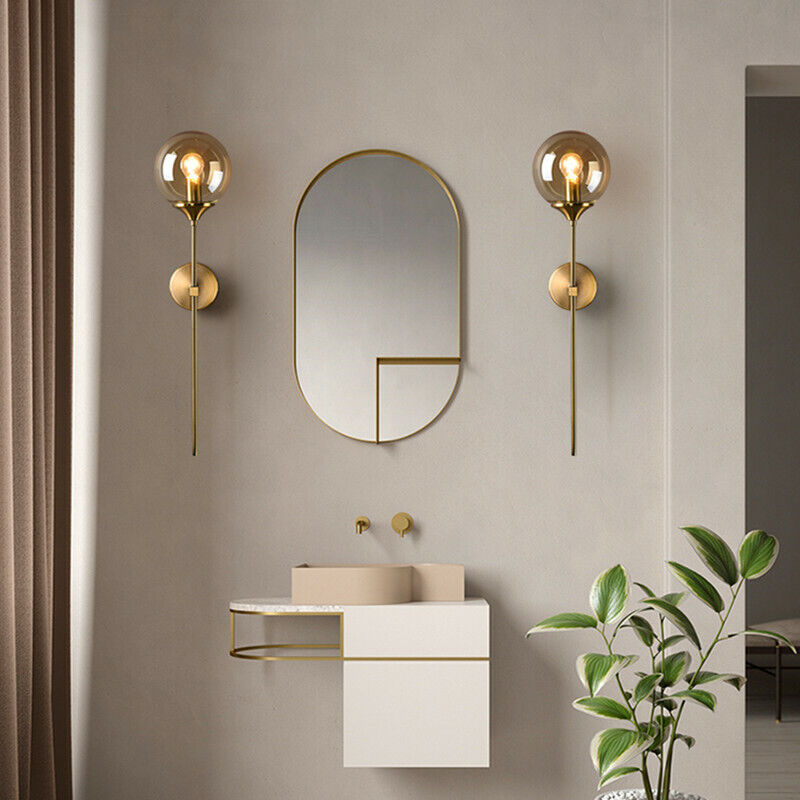 Annika amber glass ball wall sconce mounted in a dining room beside a mirror