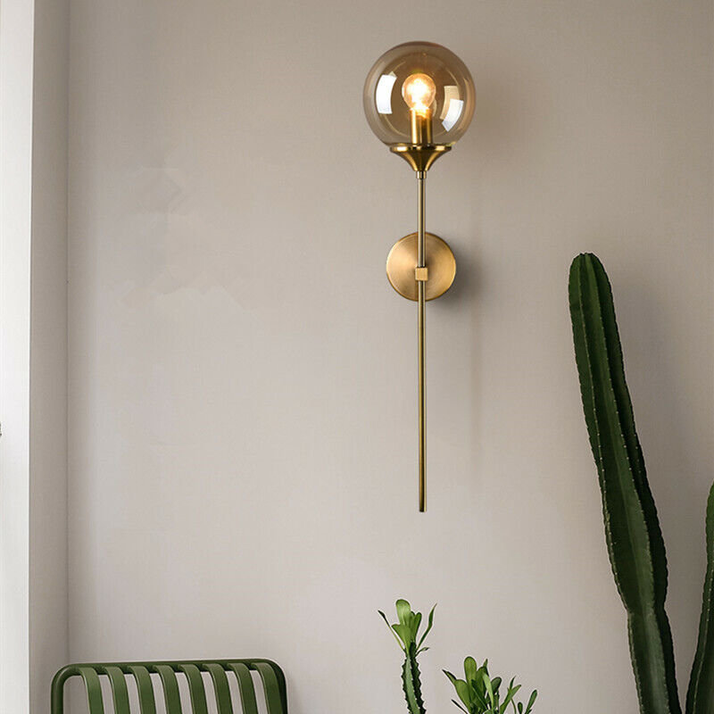 Annika amber glass ball wall sconce mounted in a dining room beside a mirror